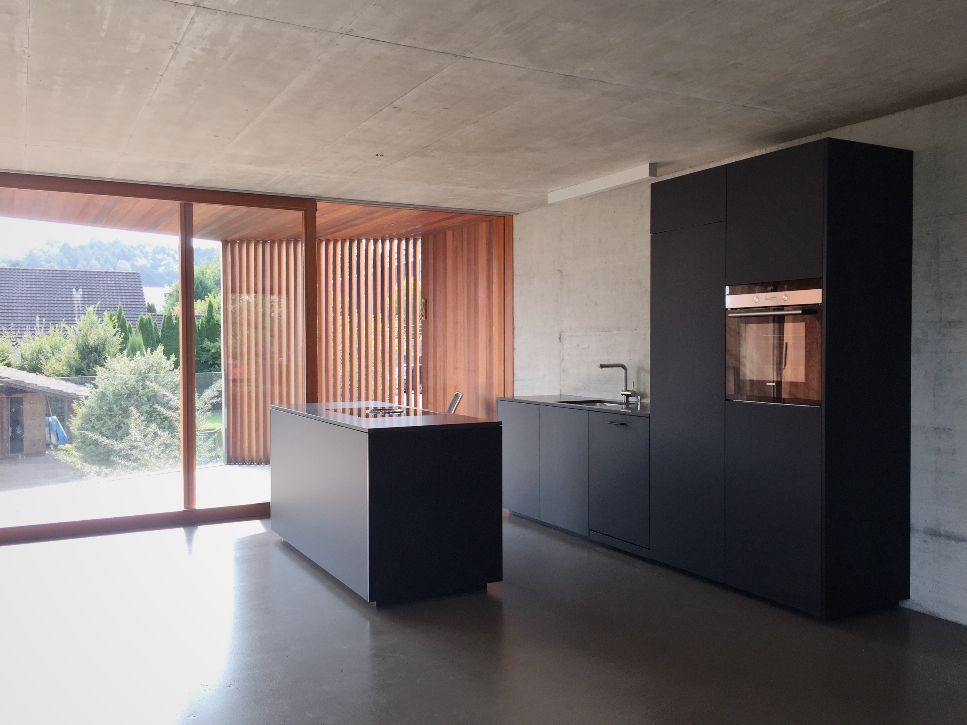 küche neubau wohnhaus einliegerwohnung schwarz modern holz beton rombach kellenberger ag schreinerei