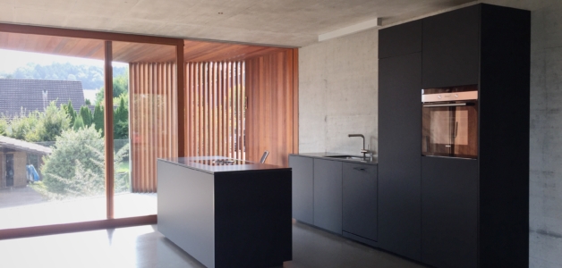 küche neubau wohnhaus einliegerwohnung schwarz modern holz beton rombach kellenberger ag schreinerei