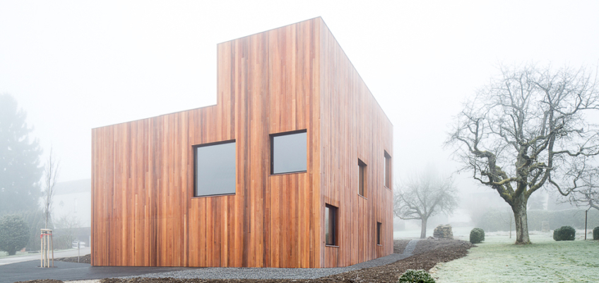 raumgestaltung neubau wohnhaus beton holz schwarz modern aussen rombach